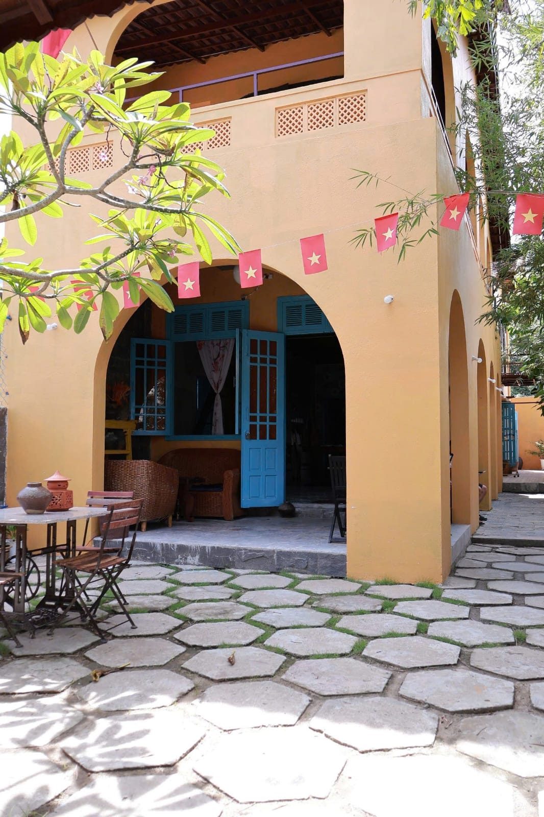 Golden arches and heritage blue doors in the courtyard of Tre Hoi An